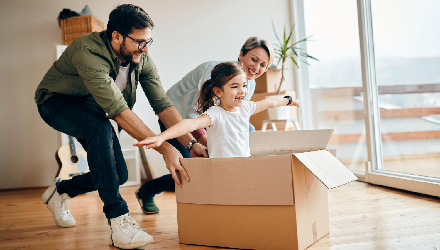 filha-feliz-se-divertindo-com-seus-pais-enquanto-se-muda-para-um-novo-apartamento